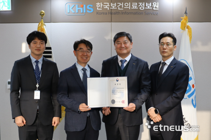 염민섭 한국보건의료정보원장(오른쪽 두번째)과 신제수 경영기획본부장이 보건복지부 장관 표창장을 들어 보이고 있다.