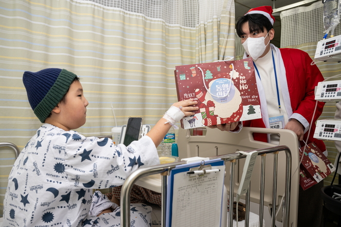 신한금융그룹 임직원들이 서울대병원의 환아들을 찾아 크리스마스 선물을 전하고 있다.