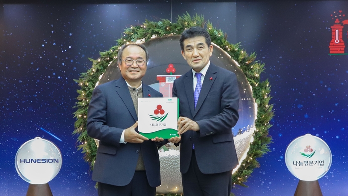 정동섭 휴네시온 대표(왼쪽)가 황인식 사랑의열매 사무총장이과 '나눔명문기업 현판'을 들고 기념촬영을 하고 있다.(휴네시온 제공)