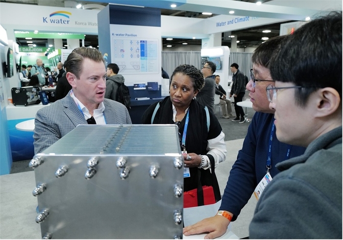 미국 라스베이거스에서 열린 CES 2026에서 외국인 방문객에게 K-water관 동반 참가기업 일렉트로워터 관계자(오른쪽)가 전기를 이용해 물속 염분과 불순물을 제거하는 수처리 설비에 대해 소개하고 있다. 사진 출처 : 수공