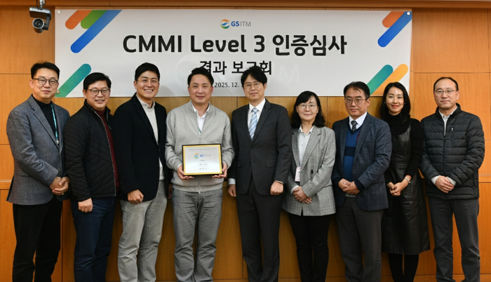 강민균 GS ITM 대표이사(왼쪽에서 세 번째)가 CMMI 3.0 버전 레벨 3 인증심사 결과 보고회에서 직원들과 기념사진을 촬영하고 있다.