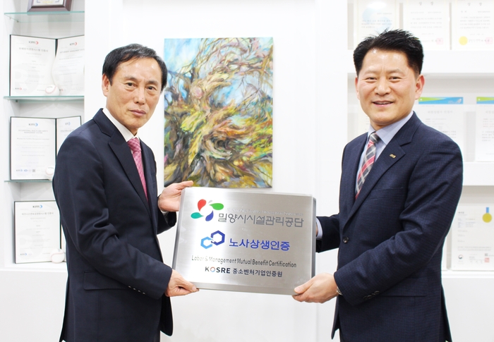엄진엽 중소벤처기업인증원 원장(오른쪽)과 김경민 밀양시시설관리공단 이사장이 노사상생 인증서 및 인증현판 수여식 후 기념촬영을 하고 있다.
