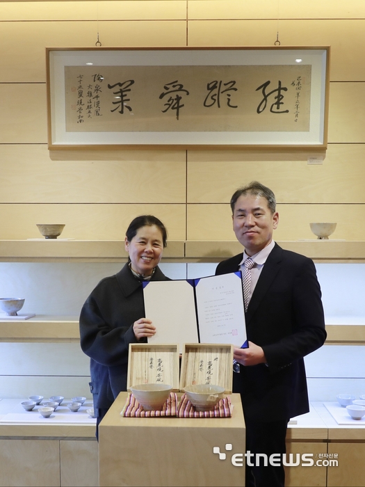 김상현 오킨스전자 부사장(오른쪽)과 천경희  도천도자미술관 대표가 기증서를 펼쳐 보이고 있다.