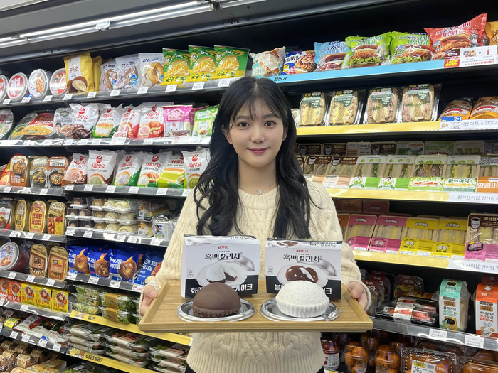 GS25에서 모델이 '흑·백 크림 케이크 2종'을 선보이고 있다.