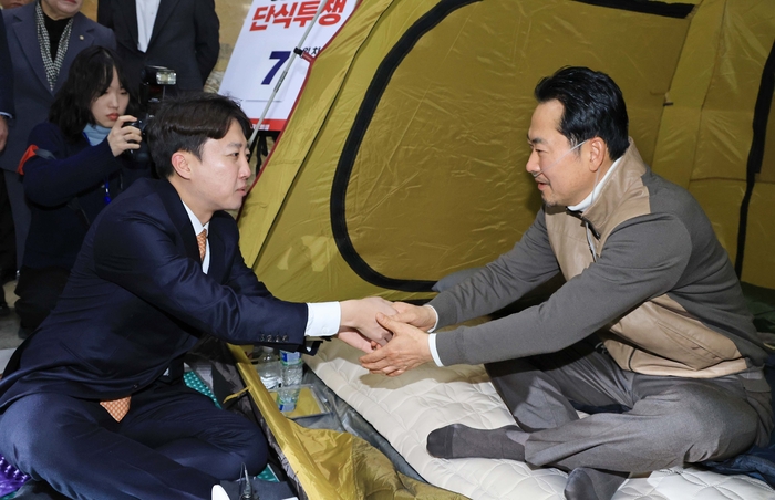 국민의힘 장동혁 대표가 지난달 21일 국회 로텐더홀 단식 농성장을 찾은 개혁신당 이준석 대표와 악수하고 있다. 연합뉴스