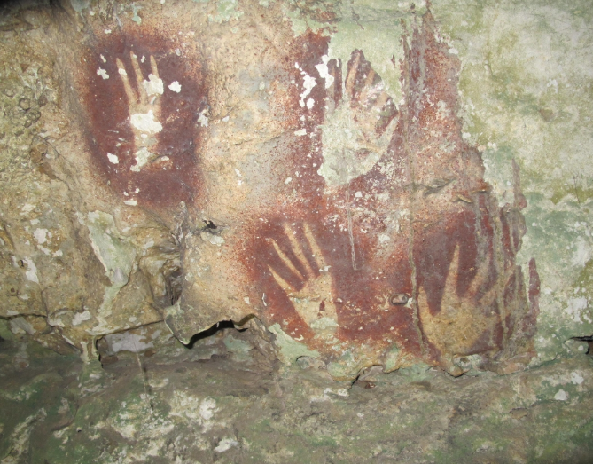 인도네시아 술라웨시 무나섬 동굴에서 발견된 6만7천800년 전에 제작된 음각 손자국 그림. 사진=호주 그리피스대학교