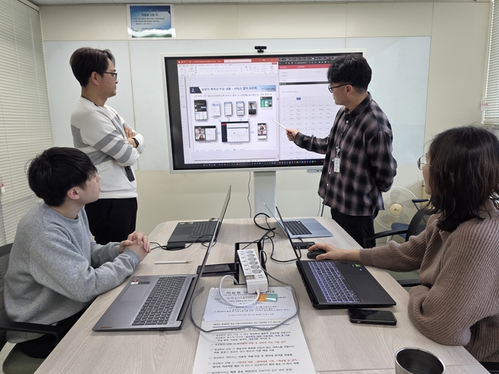 ETRI 연구진이 AI 기반 재난심리회복지원 플랫폼 화면을 기반으로 주요 기능과 서비스 흐름을 점검·논의하고 있다.