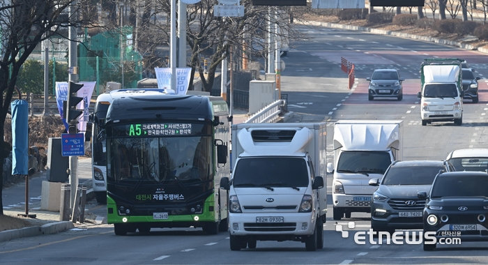 한국전자통신연구원(ETRI)가 개발한 자율주행 인공지능(AI) 기술과 도로 인프라 기술을 실제 도심과 고속화 도로를 달리는 대중교통에 적용, 30일부터 대전 카이스트에서 세종터미널까지 운행하는 대전 자율주행 시범운행지구 여객운송 서비스가 시작된다. 최적의 주행행동을 강화학습한 AI SW기술 등이 적용된 자율주행 버스는 대전 도심 구간에서는 시속 50km, 세종으로 향하는 간선급행버스체계(BRT) 구간에서는 최대 시속 80km로 주행한다. 29일 대전 유성구 대덕연구단지 인근에서 자율주행버스가 시범운행을 하고 있다.  대전=이동근기자 foto@etnews.com