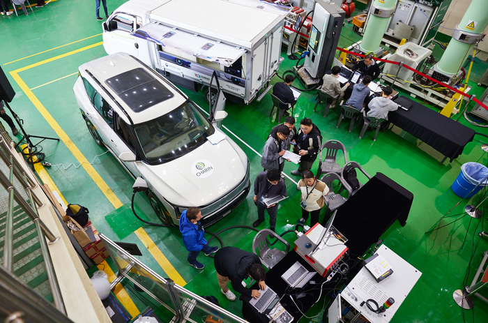 한국전기연구원이 지난해 안산분원에 개소한 '글로벌 상호운용성 시험센터(GiOTEC)'에서 기업 관계자들이 전기차와 충전기를 교차하며 상호운용성을 시험하고 있다.