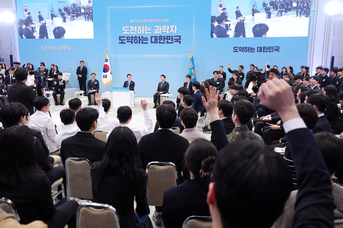 5일 청와대에서 열린 미래 과학자와의 대화 '도전하는 과학자, 도약하는 대한민국'에서 참석자들이 이재명 대통령을 향해 발언권을 요청하며 손을 들고 있다. 연합뉴스