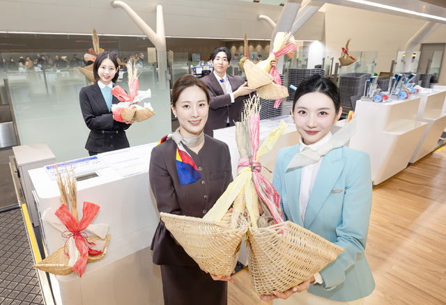 대한항공과 아시아나항공 직원들이 인천공항 제2여객터미널 탑승 수속 카운터에서 기념촬영하고 있다.