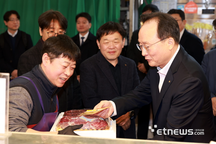 11일 망원시장에서 열린 '2026 설맞이 전통시장 사랑나눔' 행사에서 이환주 KB국민은행장이 식료품을 구입하고 있다. [사진= KB국민은행 제공]