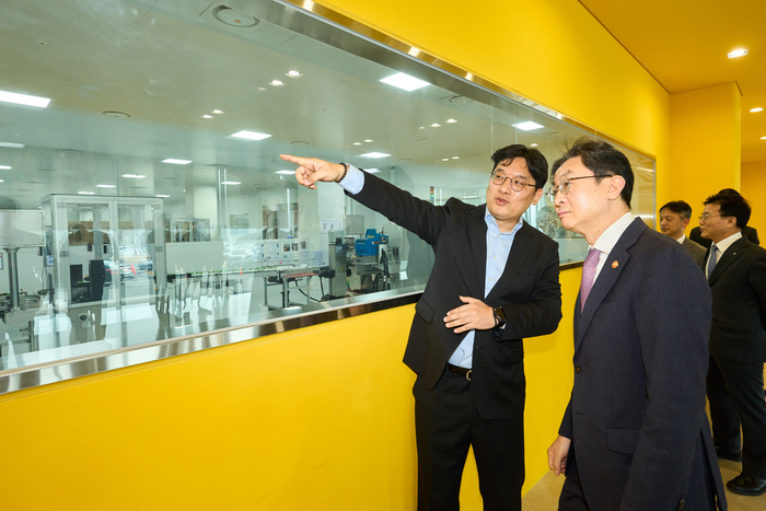 대웅제약 이승하 본부장(왼쪽)이 이억원 금융위원장에게 오송 스마트 공장의 생산 공정을 설명하고 있다.