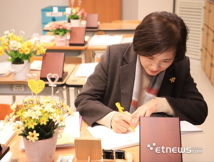 유은혜 경기도교육감 예비후보가 19일 안산 단원고 2학년6반 4.16기억교실에서 이날 생일을 맞은 고 이영만 학생의 기억노트에 편지를 쓰고 있다.