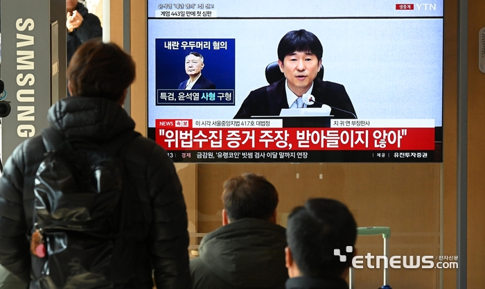 19일 서울 용산구 서울역 대합실에서 시민들이 윤석열 전 대통령의 내란 우두머리 혐의 사건 선고공판 생중계 영상을 시청하고 있다. 이동근기자 foto@etnews.com