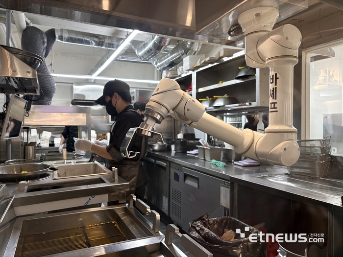 바른치킨 여의도R점에서 '바셰프' 관절형로봇이 치킨을 조리하고 있다.
