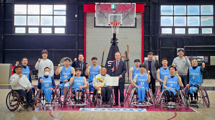 안병태 한국휠체어농구연맹 총재(가운데)가 김영무 코웨이 블루휠스 감독·선수단과 문화체육관광부 장관 표창 기념 사진을 촬영하고 있다.