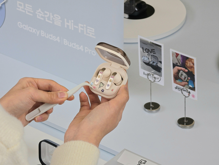 삼성 강남 '갤럭시 버즈 커스텀 랩'에서 '갤럭시 버즈4 프로'와 아크릴 모형 키링을 꾸미고 기념 사진을 촬영하는 모습