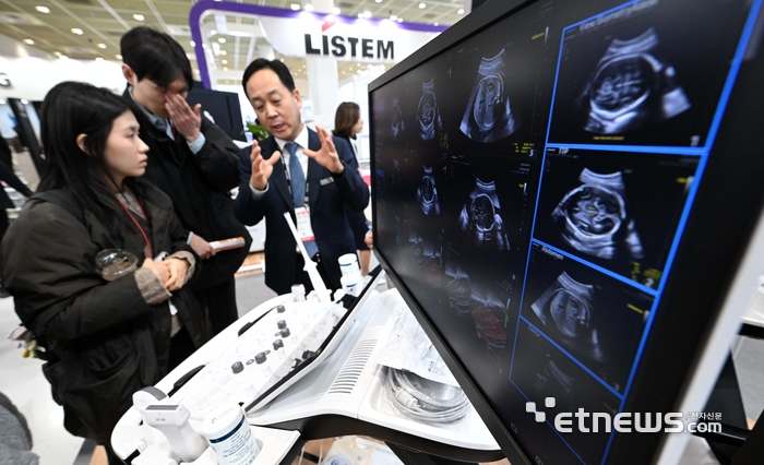 제41회 국제의료기기병원설비전시회가 19일 서울 강남구 코엑스에서 나흘 일정으로 열렸다. 삼성메디슨 부스에서 관람객이 인공지능(AI) 기반 초음파 진단 의료기기를 살펴보고 있다. 김민수기자 mskim@etnews.com