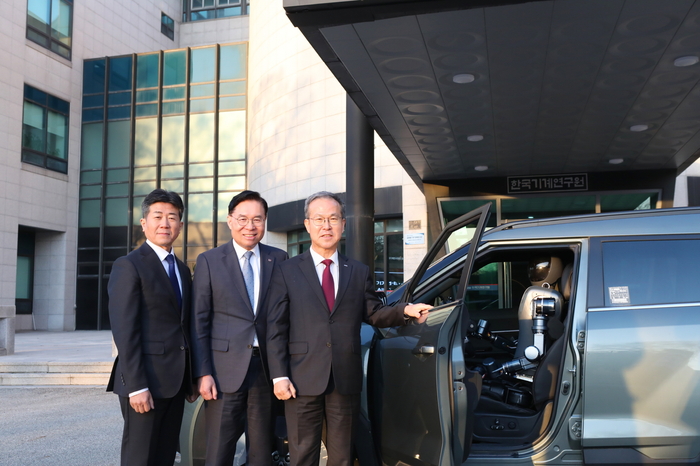 류석현 기계연 원장(가운데)과 방승찬 ETRI 원장(오른쪽), 황기영 케이지모빌리티 대표(왼쪽)가 실증에 활용할 실제 자동차와 휴머노이드 로봇을 둘러보고 기념 촬영하고 있다.