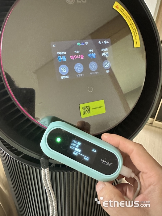 LG 퓨리케어 AI 오브제컬렉션 360° 공기청정기 M7 디스플레이 전면부. 필터 비닐을 벗기지 않은 상태의 실내 TVOC 수치를 TVOC 전용 감지기 수치와 비교하고 있다.