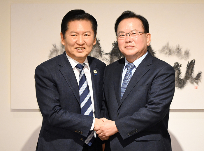 더불어민주당 정청래 대표와 김부겸 전 국무총리가 26일 서울 중구 달개비에서 회동 전 손을 맞잡고 있다. 연합뉴스