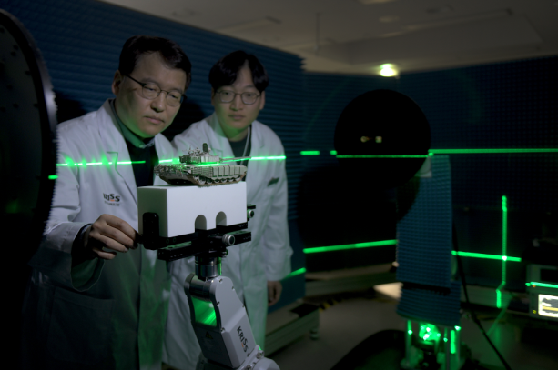 권재용 표준연 책임연구원(왼쪽)과 이상수 선임기술원이 로봇 기반 전자파 측정시스템으로 전투차량 축소모형의 위치·정렬을 조정하며 전자파 산란 특성을 평가하고 있다.