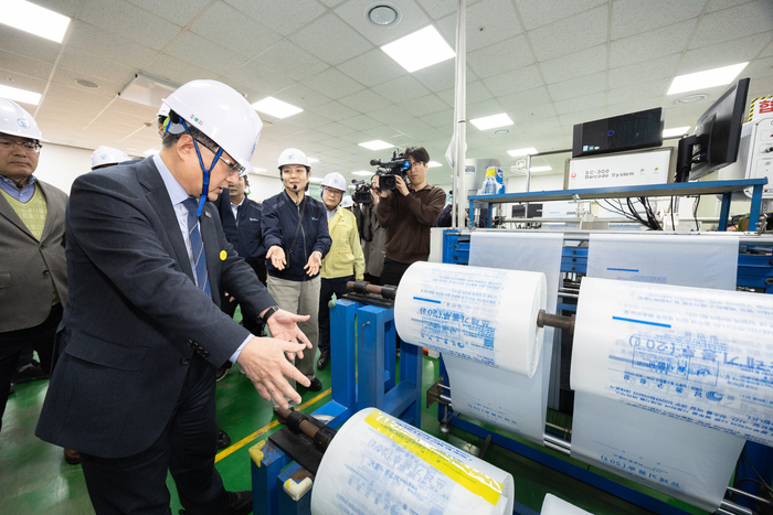 김성환 기후에너지환경부 장관이 3일 쓰레기봉투를 생산하는 인천광역시서구구립장애인직업재활시설을 방문하여 쓰레기봉투 생산 과정을 살피고 재생원료를 활용한 봉투를 비교해 보고 있다. 사진 출처 : 기후부