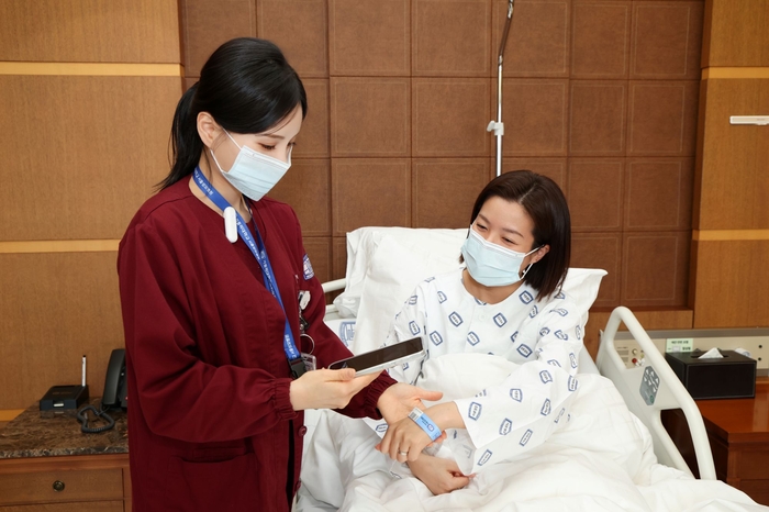 서울성모병원 간호사가 보이스 ENR로 환자 손목 밴드를 스캔하며 환자와 투약 정보를 이중 확인하고 있다.