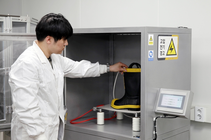 FITI시험연구원 연구원이 방화신발의 내전압성 시험을 진행하고 있다.