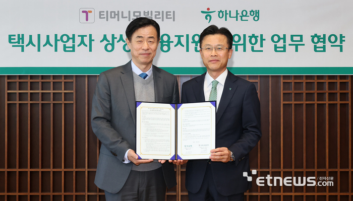 하나은행은 지난 10일 을지로 하나은행 본점에서 택시사업자의 성장 및 디지털 기반의 모빌리티 금융 프로세스 구축을 위해 티머니모빌리티와 '택시사업자 상생 금융지원을 위한 업무협약'을 체결했다. 이날 협약식에 참석한 서유석 하나은행 기업그룹 부행장(오른쪽)이 조동욱 티머니모빌리티 대표와 협약서를 들고 기념 촬영하고 있다. [사진= 하나은행 제공]