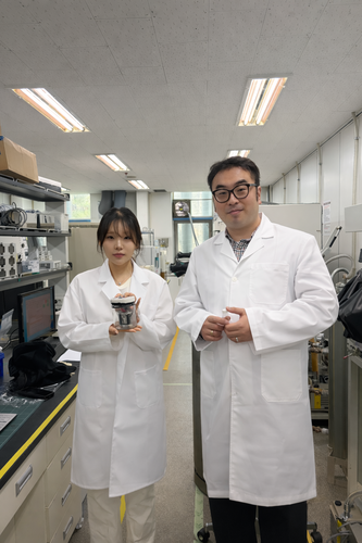 배진영 자체인턴(사진 왼쪽)과 김태효 수석연구원이 개발된 전해질을 적용한 전고체 전지 셀을 들어 보이고 있다.