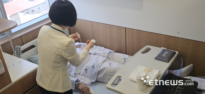 고지선 동탄시티병원 간호본부장이 입원 환자에게 씨어스의 웨어러블 장비를 부착하는 모습을 시연하고 있다. (사진=배옥진)