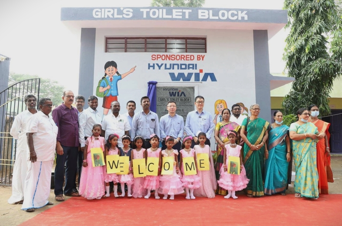 현대위아 임직원이 인도 센가두에서 열린 여성 화장실 준공 행사에서 인도 주민과 여학생의 환영을 받고 있다.