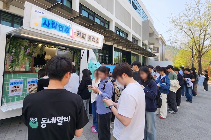 지난 15일 서울대 관악캠퍼스에서 열린 '사람인증 커피 충전소' 이벤트에 참가한 대학생들이 음료를 받기 위해 긴 줄을 늘어서고 있다. 〈자료 사람인〉