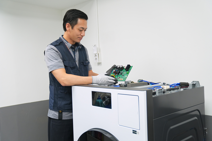 삼성전자서비스 엔지니어가 세탁기를 수리하고 있다.
