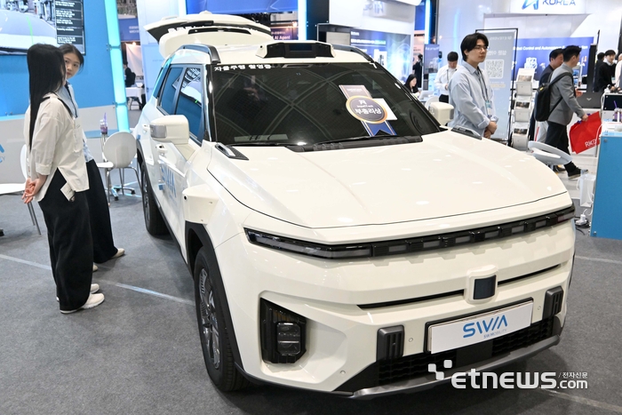 국내 최고 정보통신기술(ICT) 축제 '월드IT쇼 2026'이 22일 서울 강남구 코엑스에서 열렸다. 에스더블유엠 부스에서 관람객이 자율주행 로봇택시를 살펴보고 있다. 김민수기자 mskim@etnews.com