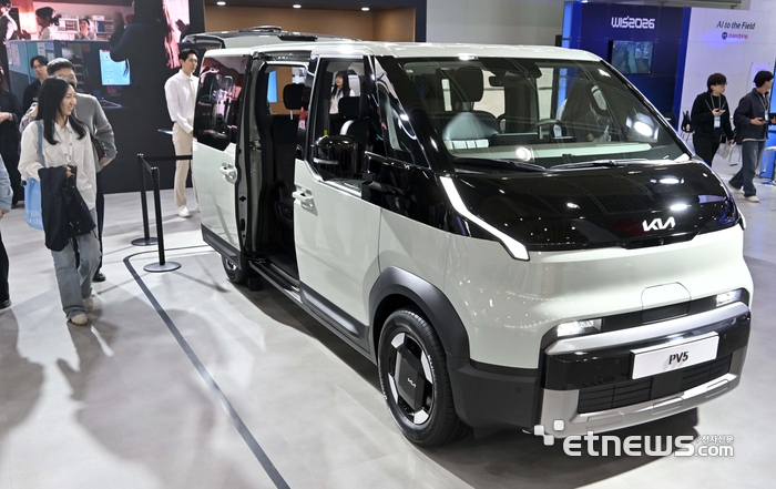 국내 최고 정보통신기술(ICT) 축제 '월드IT쇼 2026'이 22일 서울 강남구 코엑스에서 열렸다. 기아 부스에서 관람객이 PV5 차량을 살펴보고 있다. 김민수기자 mskim@etnews.com