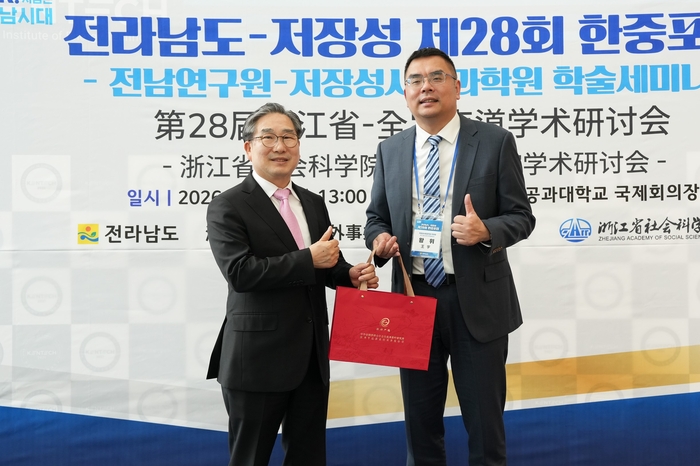 강상구 나주시장 권한대행(왼쪽)과 왕위 저장성사회과학원 부원장(오른쪽)이 기념품을 주고받고 있다.