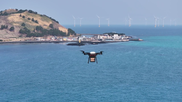 제주 금능포구 일원에서 화물을 탑재한 드론이 비행하며 실증을 수행하고 있다. (우주청 제공)
