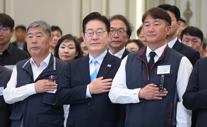 이재명 대통령이 1일 청와대 영빈관에서 열린 노동절 기념식에서 양대 노총 위원장을 비롯한 참석자들과 국민의례를 하고 있다. 왼쪽부터 김동명 한국노총 위원장, 이 대통령, 양경수 민주노총 위원장. 연합뉴스.