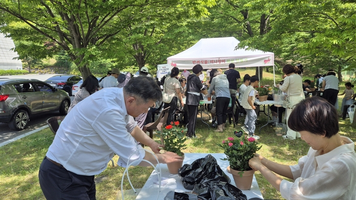 윤제정 광주기후에너지진흥원 원장(왼쪽)이 16일 열린 '제4회 CSU텃밭정원 만들기' 기후농부학교 프로그램 일환 반려식물 미니장미 심기행사에 참여해 화분을 만들고 있다.