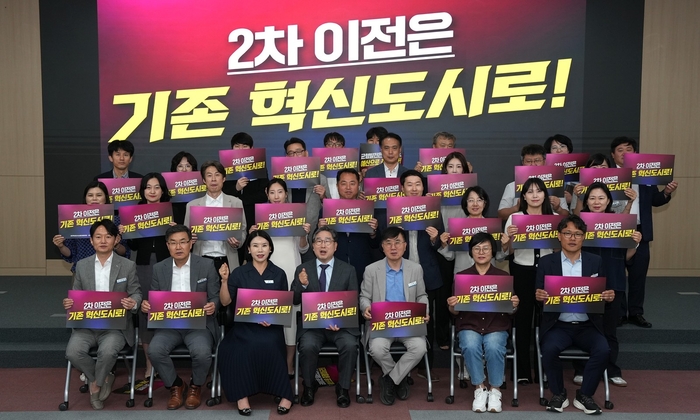 나주시가 19일 시청 대회의실에서 개최한 '공공기관 유치추진단 2차 실무회의' 참석자들이 '2차 공공기관 이전은 기존 혁신도시로!'라는 내용의 피켓을 들고 단체 퍼포먼스를 하고 있다.