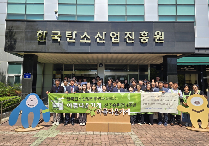 한국탄소산업진흥원 임직원들이 아름다운가게와 함께하는 자선바자회를 운영하고 기념촬영을 하고 있다.