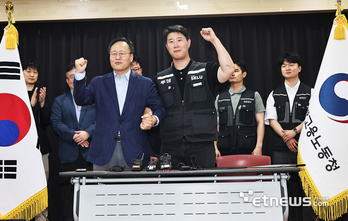 20일 경기도 수원시 장안구 경기고용노동청에서 열린 삼성전자 임금협상을 마친 후 여명구 삼성전자 DS(디바이스솔루션·반도체 사업 담당) 피플팀장과 최승호 삼성그룹 초기업노동조합 삼성전자지부 위원장이 잠정 합의안에 서명한 후 파이팅을 외치고 있다. 연합뉴스