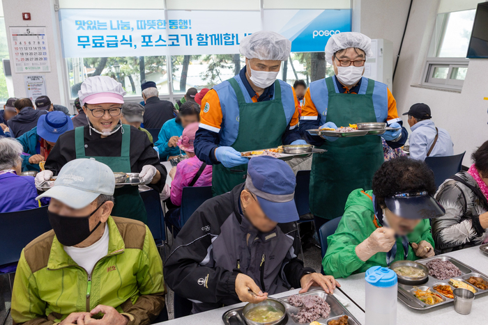 이희근 포스코 사장(뒷줄 가운데)과 급식대가 이미영 셰프, 오창석 포항제철소 제강부 명장이 포항 송도동 송림노인복지관에서 특별 배식 봉사를 하고 있다. 포스코