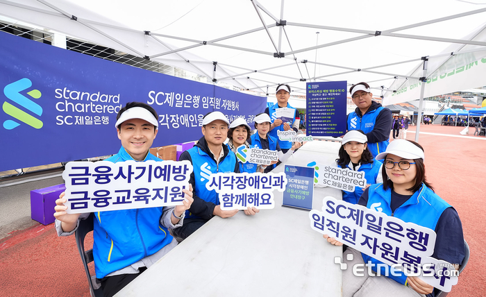 지난 23일 서울 용산구 효창운동장에서 열린 '제13회 시각장애인가족 한마음축제'에서 SC제일은행 임직원 봉사자들이 시각장애인을 위한 '금융사기예방 및 금융교육 부스'를 운영하며 기념 촬영하고 있다. [사진= SC제일은행 제공]