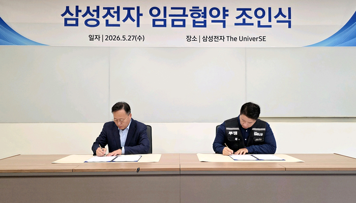 여명구 삼성전자 부사장(왼쪽)과 최승호 삼성그룹 초기업노동조합 삼성전자 지부 위원장이 27일 경기 용인시 기흥에 위치한 삼성전자 The UniverSE에서 열린 2026년 임금협약 조인식에서 서명하고 있다.