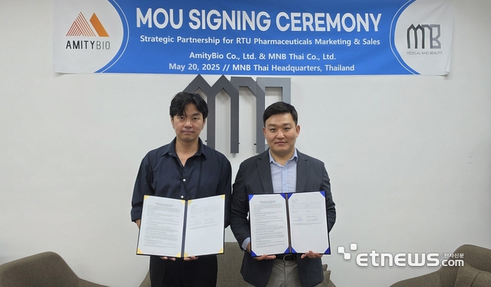 권순우 MNB Thai 대표(왼쪽)와 조기환 에머티바이오 대표가 MOU를 맺고 협약서를 펼쳐 보이고 있다.