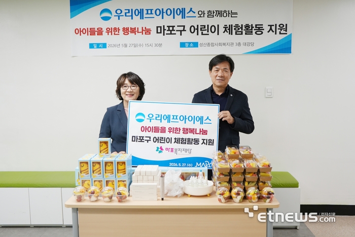 (왼쪽부터) 김은영 마포복지재단 이사장과 고영수 우리FIS 대표가 지난 27일 성산종합사회복지관에서 사회공헌활동 진행 후 기념사진을 촬영하고 있다. [사진= 우리FIS 제공]
